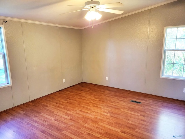 unfurnished room with light hardwood / wood-style floors, plenty of natural light, crown molding, and ceiling fan