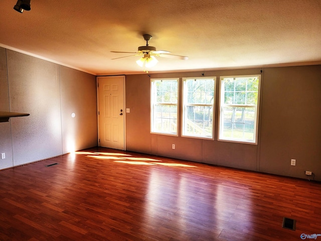 spare room with hardwood / wood-style floors, ceiling fan, ornamental molding, and a textured ceiling