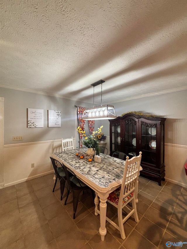 dining area with a textured ceiling and ornamental molding