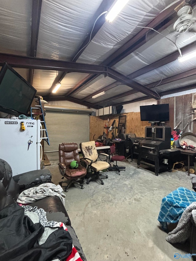 garage featuring white fridge and wood walls