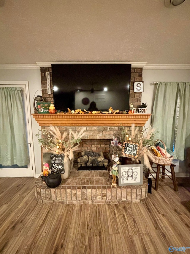 interior details with crown molding, a fireplace, wood-type flooring, and a textured ceiling