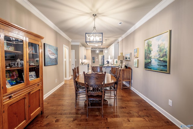 2522 Lindisfarne Dr SW, Decatur, AL 35603 - dining area with a chandelier, crown molding, dark wood-type flooring, and baseboards