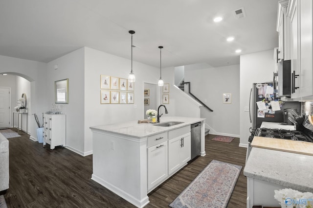 kitchen with dark wood finished floors, baseboards, appliances with stainless steel finishes, and a sink
