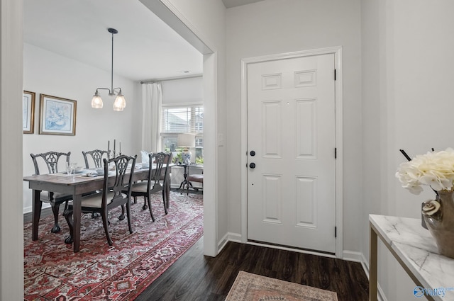 foyer entrance with dark wood-style flooring and baseboards