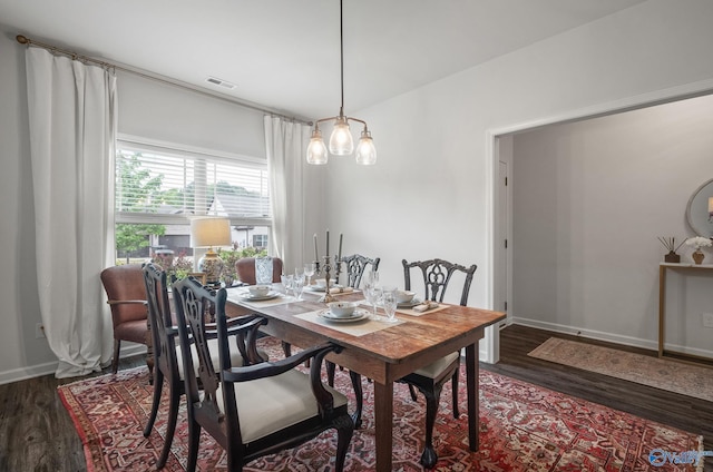 dining area featuring wood finished floors, visible vents, and baseboards