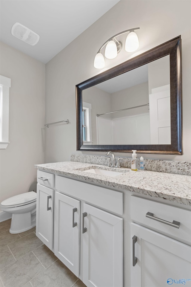 bathroom with vanity, toilet, and walk in shower