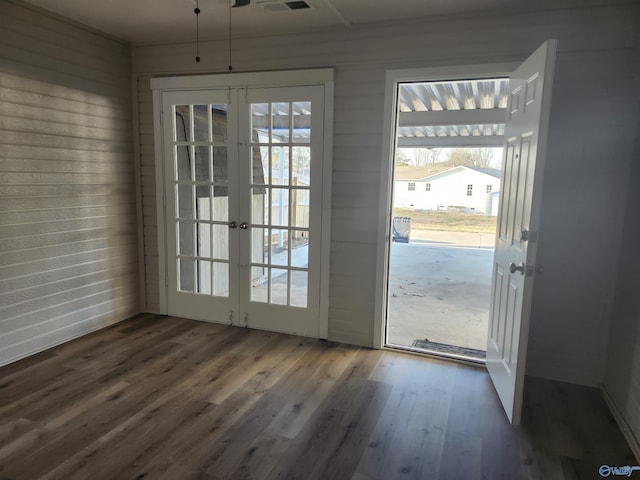 doorway with wooden walls, french doors, and wood finished floors