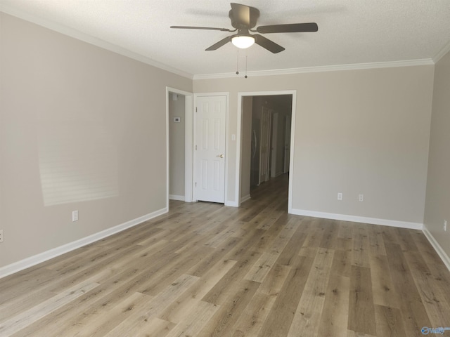 empty room with light wood-type flooring, baseboards, ceiling fan, and crown molding