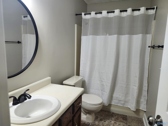 full bathroom with stone finish flooring, toilet, shower / tub combo with curtain, and vanity