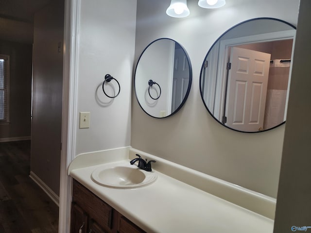 bathroom featuring vanity, baseboards, and wood finished floors