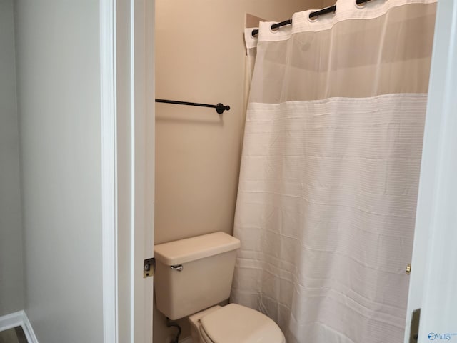 full bathroom with curtained shower and toilet