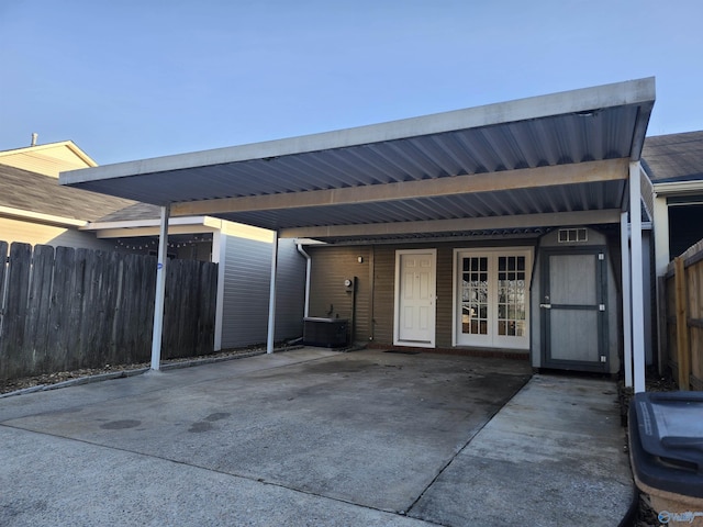 exterior space with french doors, a carport, central AC unit, and fence