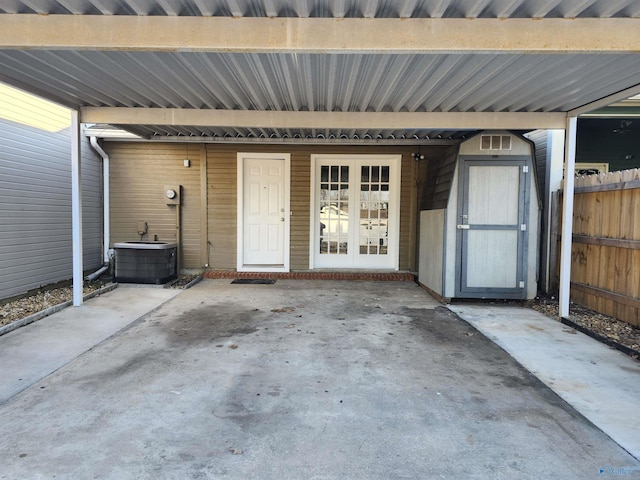 view of exterior entry featuring central air condition unit and fence