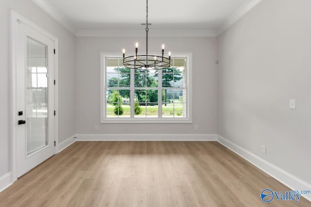 unfurnished dining area featuring crown molding, a chandelier, and light wood-type flooring