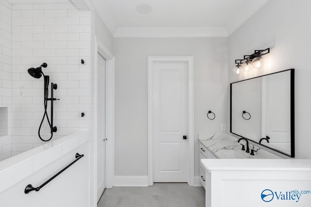 bathroom featuring vanity, ornamental molding, and tiled shower