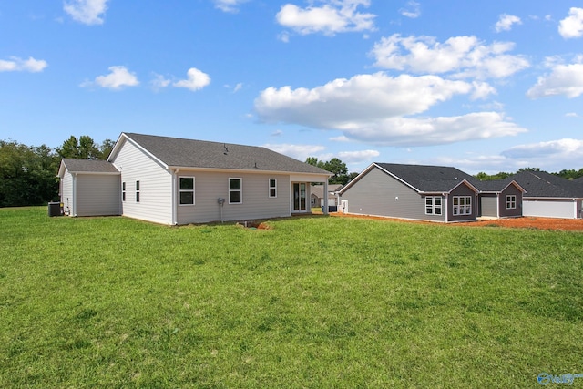 back of house featuring a yard and central AC unit