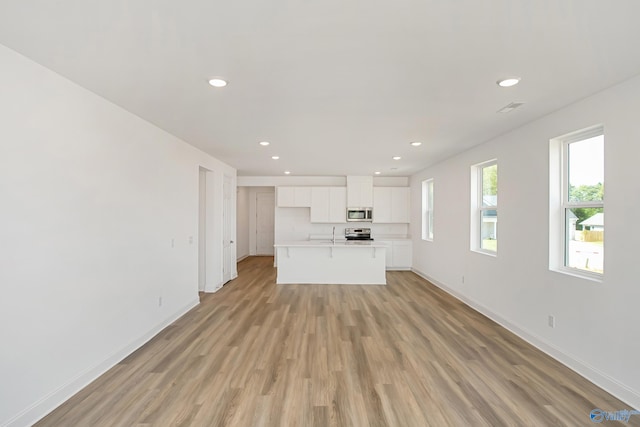 unfurnished living room featuring sink and light wood-type flooring