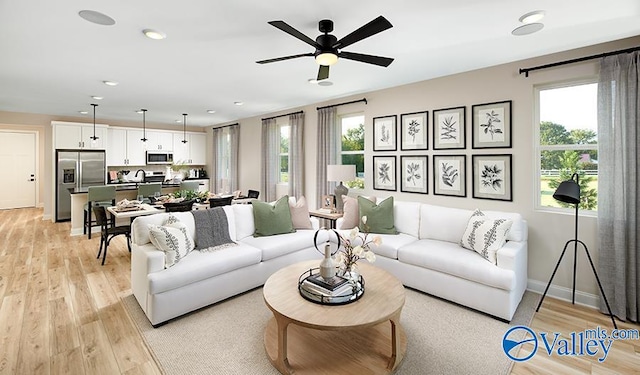 living room with ceiling fan, a healthy amount of sunlight, and light hardwood / wood-style floors