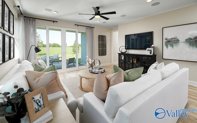 living room with ceiling fan and light hardwood / wood-style floors