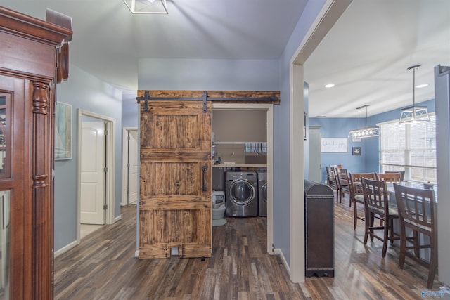 interior space featuring a barn door, washer and dryer, and dark hardwood / wood-style floors