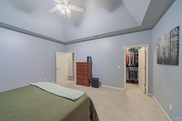 carpeted bedroom with a spacious closet, a closet, ceiling fan, and a towering ceiling