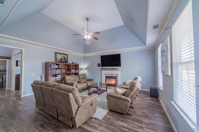 living room with lofted ceiling, a high end fireplace, dark wood-type flooring, and ceiling fan