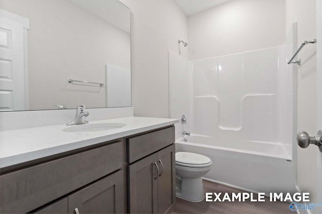 full bathroom featuring hardwood / wood-style flooring, shower / washtub combination, vanity, and toilet