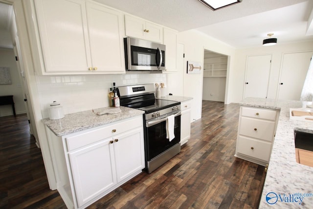 2520 Excalibur Dr SE, Huntsville, AL 35803 - kitchen featuring stainless steel appliances, decorative backsplash, white cabinets, dark wood-type flooring, and light stone countertops