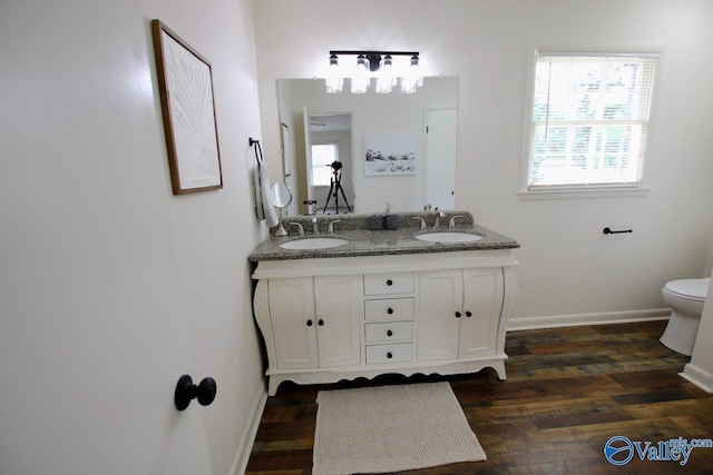 2520 Excalibur Dr SE, Huntsville, AL 35803 - bathroom featuring double vanity, baseboards, toilet, and wood finished floors
