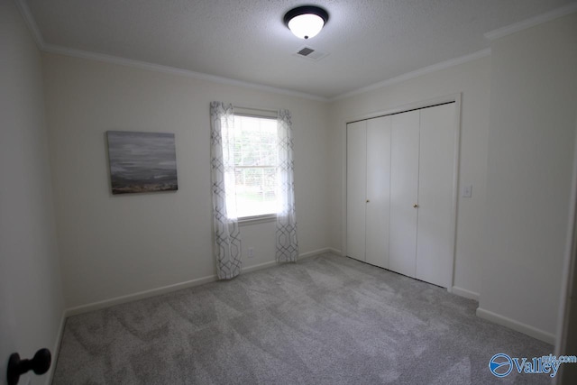2520 Excalibur Dr SE, Huntsville, AL 35803 - unfurnished bedroom with carpet, ornamental molding, baseboards, a closet, and a textured ceiling