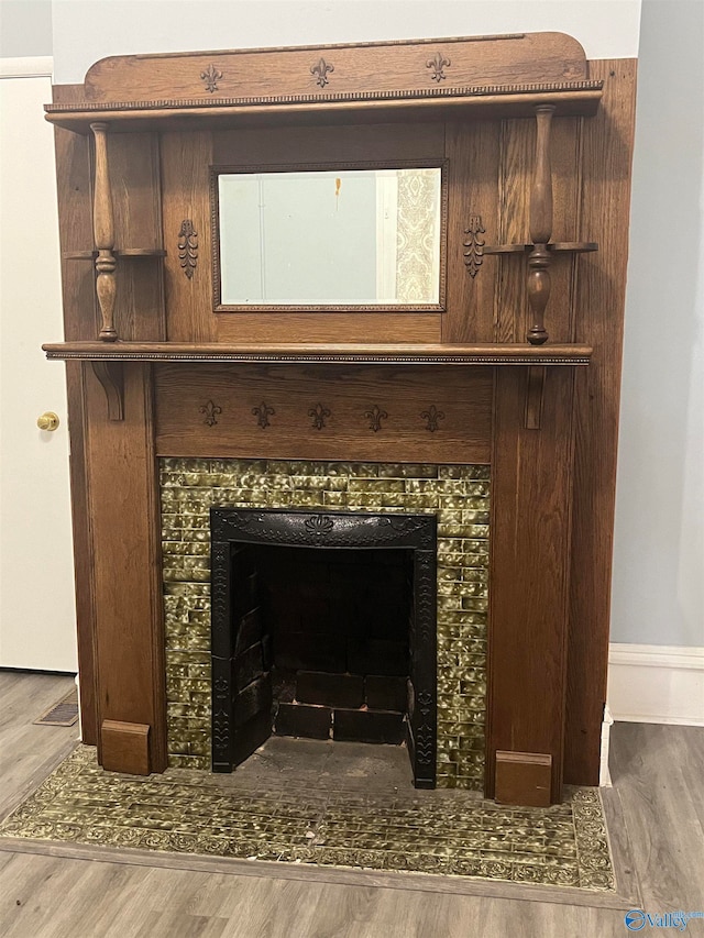 room details featuring a tiled fireplace and hardwood / wood-style floors