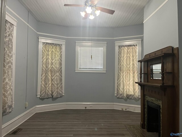 interior space with dark wood-type flooring, wood ceiling, and ceiling fan