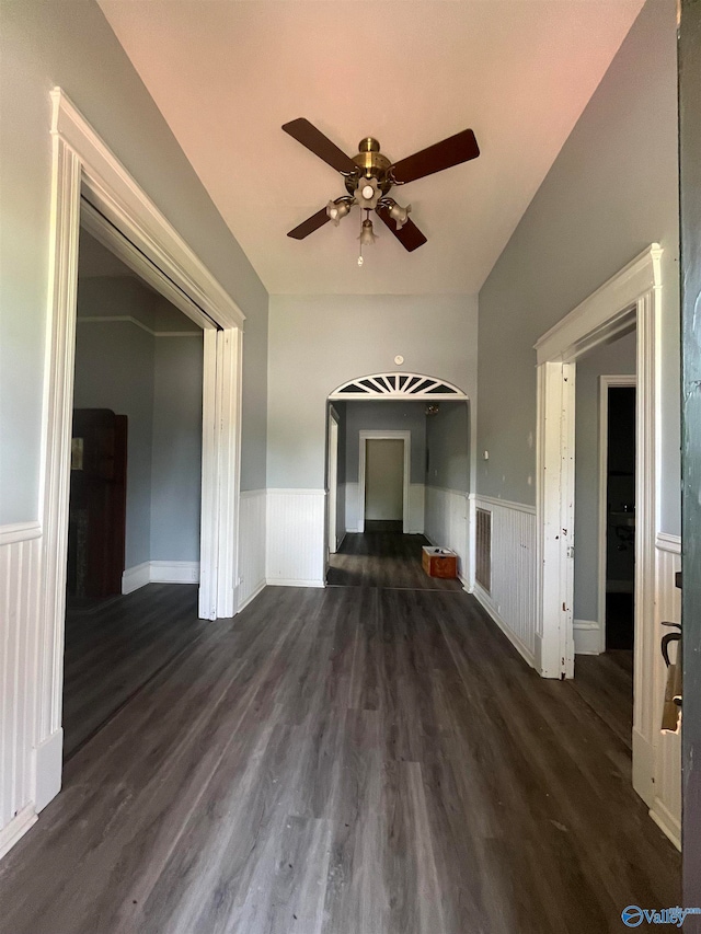 unfurnished living room featuring ceiling fan and dark hardwood / wood-style flooring