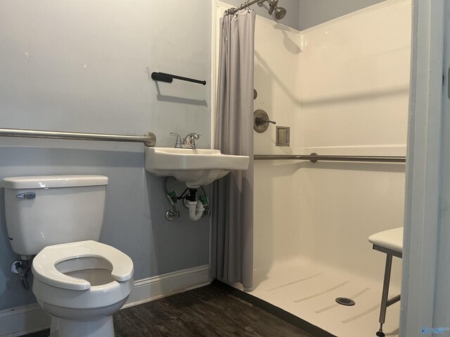 bathroom featuring walk in shower, toilet, and wood-type flooring