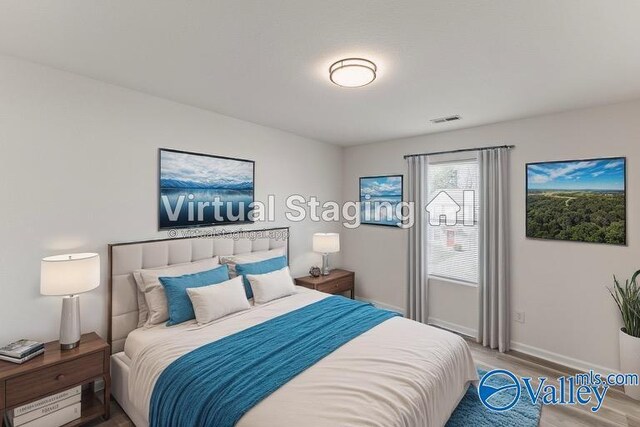 bedroom with visible vents, baseboards, and wood finished floors