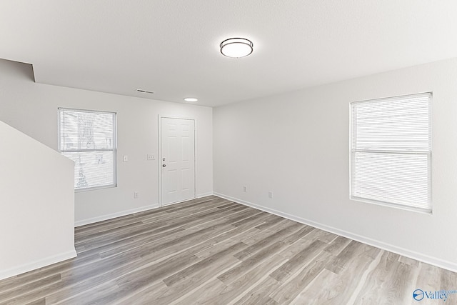 unfurnished room featuring light wood-type flooring and baseboards