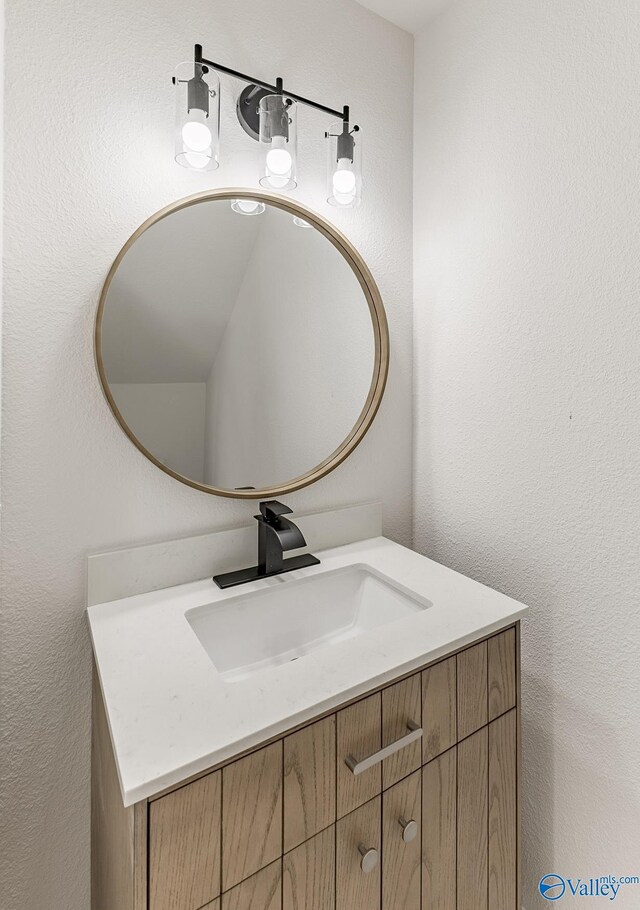 bathroom featuring a textured wall and vanity