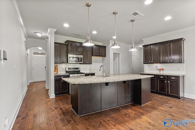 107 Duchess Dr, Madison, AL 35758 - kitchen featuring appliances with stainless steel finishes, tasteful backsplash, dark brown cabinets, dark wood-style floors, and crown molding