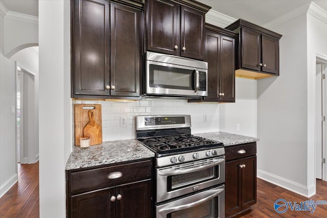 107 Duchess Dr, Madison, AL 35758 - kitchen featuring stainless steel appliances, crown molding, dark wood-type flooring, arched walkways, and tasteful backsplash