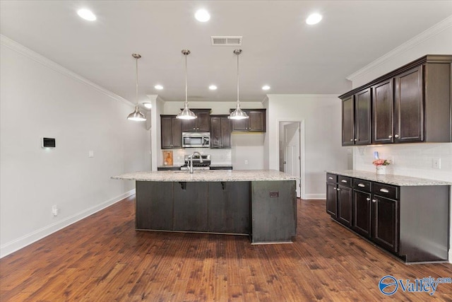 107 Duchess Dr, Madison, AL 35758 - kitchen featuring stainless steel microwave, decorative backsplash, crown molding, dark brown cabinetry, and light stone countertops