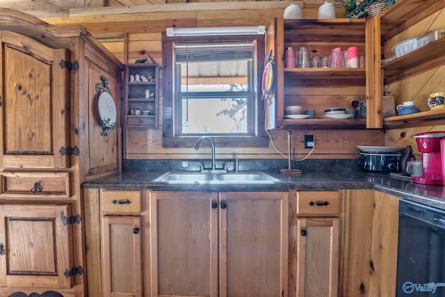 kitchen featuring black dishwasher, wooden walls, and sink