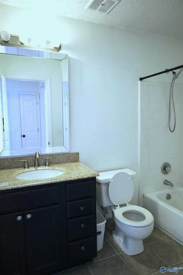 full bathroom featuring tile patterned flooring, a textured ceiling, toilet, vanity, and tiled shower / bath combo