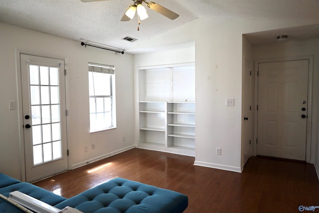 living room with a textured ceiling, a healthy amount of sunlight, hardwood / wood-style flooring, and ceiling fan