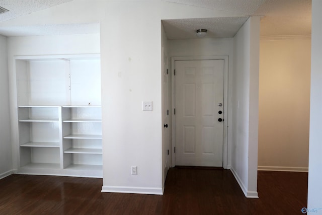 interior space with a textured ceiling and dark hardwood / wood-style flooring