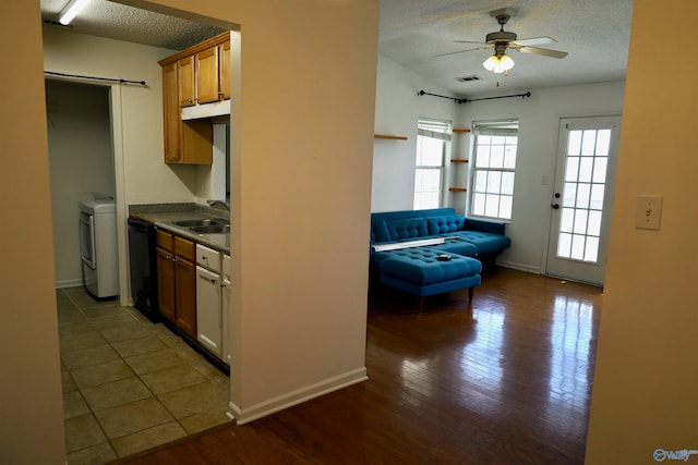 kitchen with dishwasher, sink, a textured ceiling, dark wood-type flooring, and ceiling fan