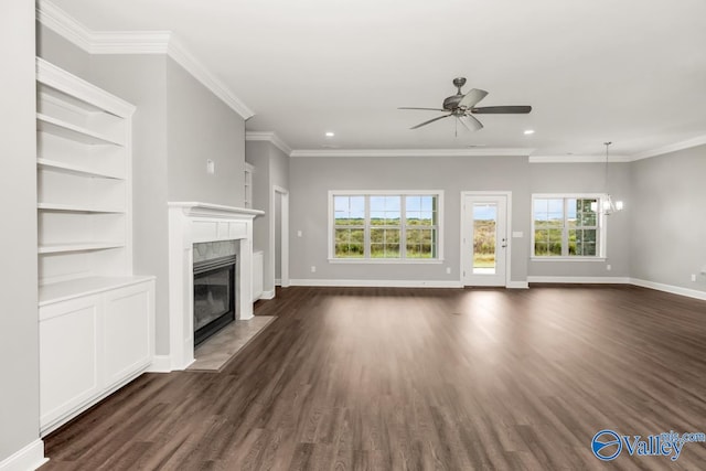 unfurnished living room with ceiling fan with notable chandelier, dark wood-type flooring, a premium fireplace, and ornamental molding