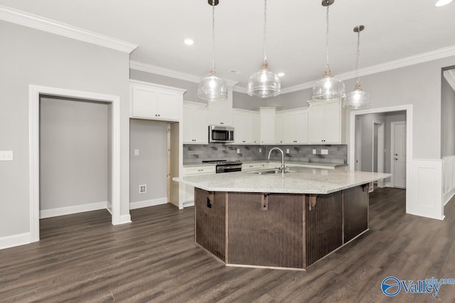 kitchen with dark wood-style flooring, white cabinets, ornamental molding, stainless steel appliances, and a sink