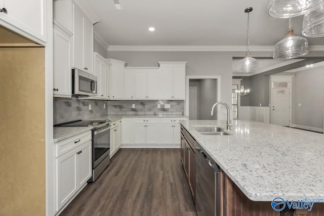 kitchen featuring dark wood-style flooring, ornamental molding, stainless steel appliances, a sink, and white cabinets