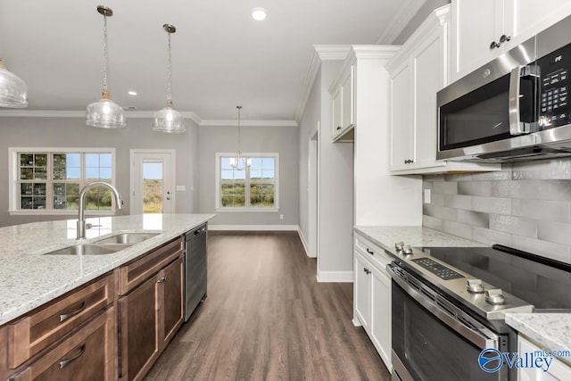 kitchen featuring decorative light fixtures, white cabinets, stainless steel appliances, and sink