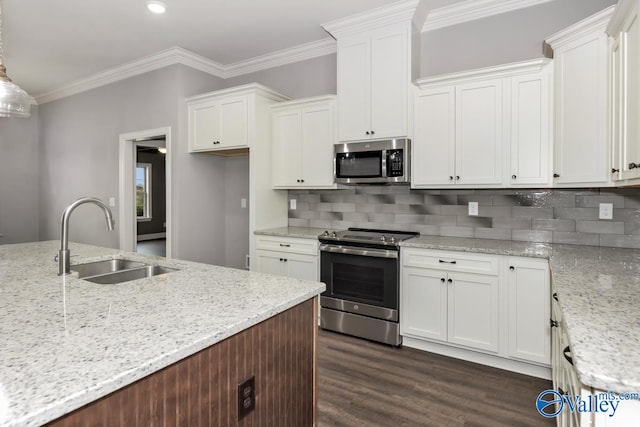 kitchen with light stone countertops, decorative light fixtures, stainless steel appliances, sink, and white cabinetry